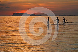 Fishermen silhouetting against sunset