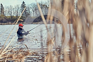 Fishermen spin fishing using chest waders photo