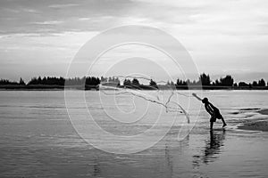 Fishermen throw a fishing net to catch fishes