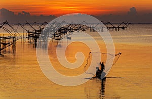 Fishermen throwing fishing net from his boat early morning