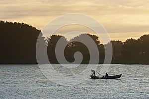 Fishermen traveling by boat on the river.