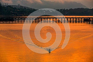 Fishermen are using boats to pass through the Mon Bridge. Mon Bridge is the long wooden bridge. Attanusorn Bridge. Sangkhla Buri,