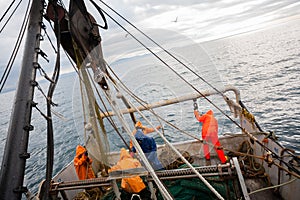 Fishermen in waterproof clothing on the deck of the fishing vessel