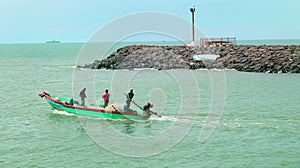 Fishermen at works on the wooden motor boat.