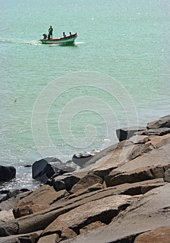 Fishermen at works on the wooden motor boat.