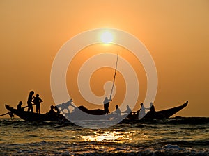 Fishers' boat in sunset