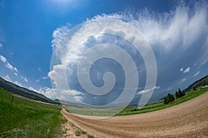 Fisheye view of a road leading to a severe warned thunderstorm over the Black Hills in South Dakota