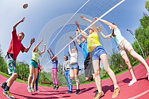 Fisheye view of teens playing volleyball on ground