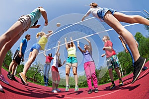 Fisheye view of teens playing volleyball outside