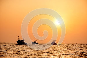 Fishin industry boats at sea back to port at sunset