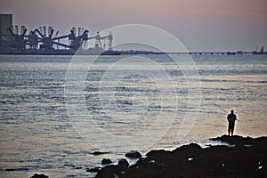 Fishing alone at the mouth of the Tagus river in Lisbon