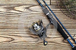 Fishing background. tackle - fishing spinning, reel and metal net on dark wooden background. Top view. Copy-space