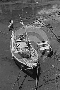 Fishing boast floating on mud. Black and white photo