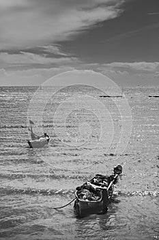Fishing boast floating on the sea. Black and white photo