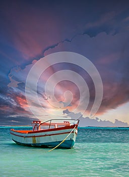 Fishing boat anchored in a peaceful bay in Aruba under dramatic sky