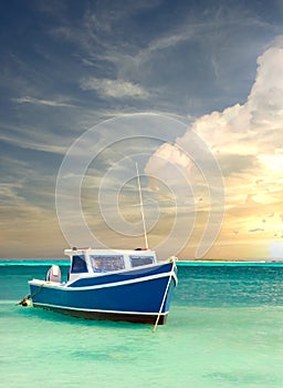 Fishing boat anchored in a peaceful bay in Aruba under dramatic sky