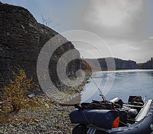 Fishing boat on the background of an autumn landscape on the shore of the northern river