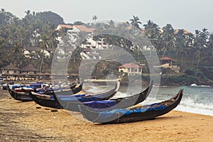 Fishing boat on the beach the ocean on a background of palm trees in Kovalam, Kerala, India. Copy, empty space for text