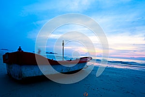 Fishing boat on beach on sunset