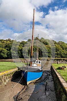 Fishing boat beached in mud by tidal River Tamar in Devon