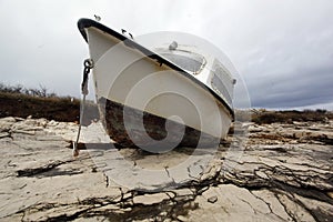 Fishing boat beached on a rock photo