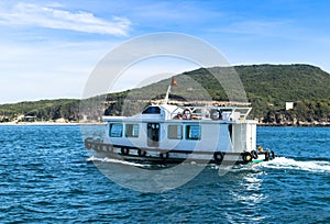 Fishing boat in the blue ocean in the early morning, rocks background