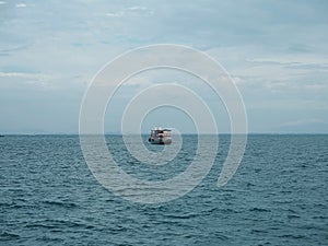 Fishing boat in blue sea with clouds sky background in Thailand.