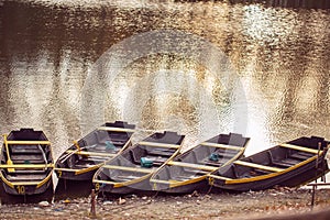 fishing boat in a calm lake water/old wooden fishing boat/ wooden fishing boat in a still lake water