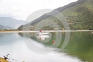 Fishing boat in a calm lake water/old wooden fishing boat/ wooden fishing boat in a still lake water