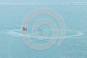 Fishing boat is circling to catch fish on the sea