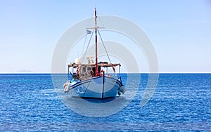 Fishing boat colorful moored at open sea, Ios island Cyclades, Greece
