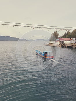 Fishing boat crossing under Ulee Lheue Brigde, Aceh, Indonesia. photo
