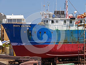 A fishing boat in dire need of repairing in dry dock in Cape Town