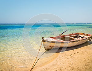 Fishing boat docked to coast on the beautiful beach of Crete, Gr