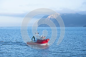 Fishing boat entering Bermeo with the Ogo?o cape in the background, Euskadi photo