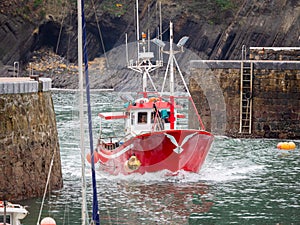 Fishing boat entering a port of a village in the Basque country, Spain