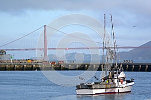Fishing boat in Fisherman wharf against the Golden Gate Bridge i
