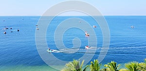 Fishing boat floating on the sea with clear blue sky and coconut or palm tree foreground