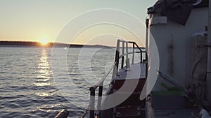 Fishing boat floats in the sea at sunset. Clip. View from the barge to the sea horizon. Romantic swim at dawn in the sea