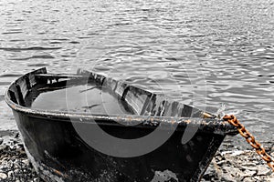 Fishing boat full of water on the shore