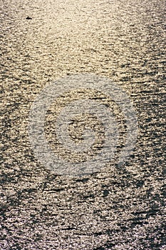 Fishing boat, golden sunlight reflected in a waves at sunset, dark contrast background seascape, top view, beautiful sea