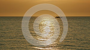 Fishing Boat On The Horizon At Sea. Abstract Small Waves On Calm Water Surface In Motion.