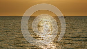 Fishing Boat On The Horizon At Sea. Abstract Small Waves On Calm Water Surface In Motion.