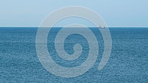 Fishing Boat On The Horizon At Sea. Abstract Small Waves On Calm Water Surface In Motion. Real time.