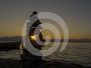 fishing boat on the lake, zen stones and serenity, simplicity and peace at sunset