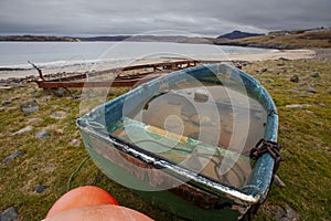 Fishing boat on Melness beach filled with rain water