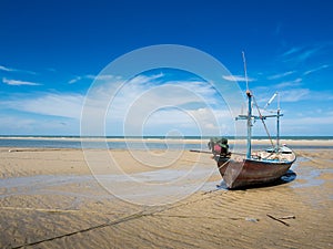 The fishing boat moored at the beach.