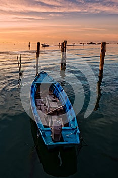 Fishing boat moored on cliff at sunset.