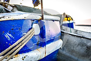 Fishing boat moored or docked at pier in sunset