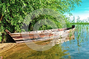 Fishing boat moored on lake by blue sky